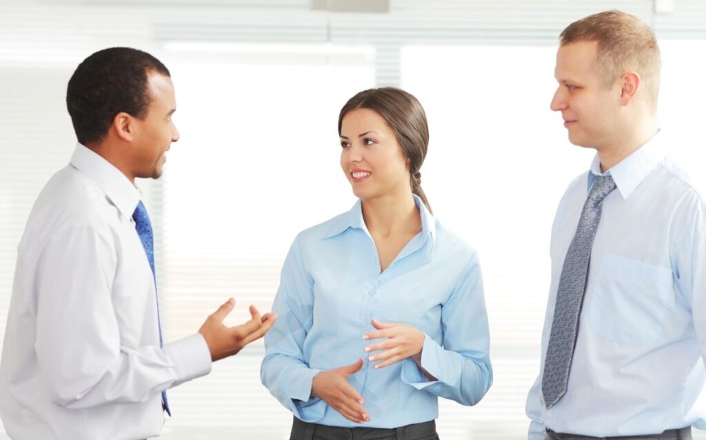 two men wearing blue shirt talking about communication skills at work