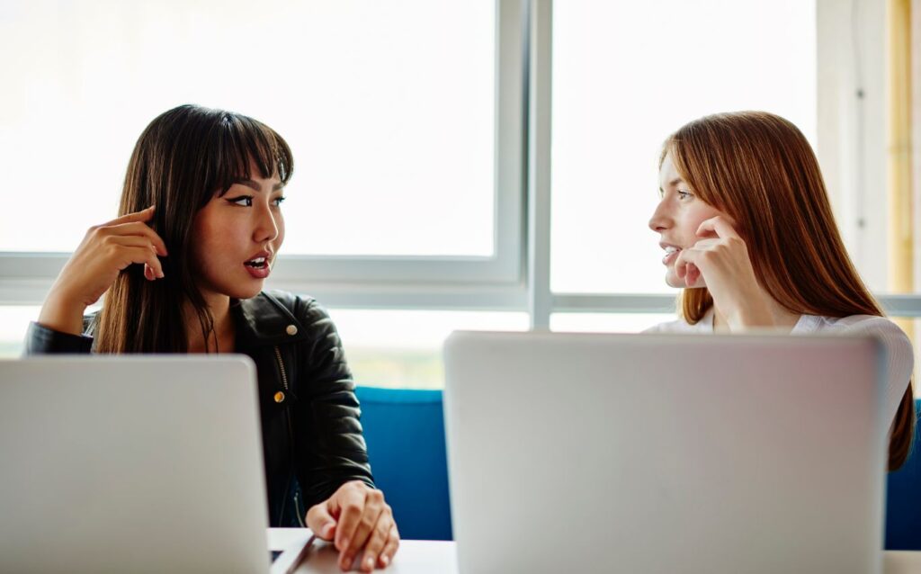 two women discussing the differences between copywriter duties and content writers